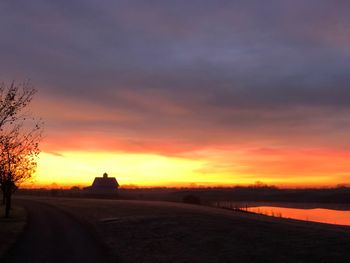 Scenic view of silhouette landscape against orange sky
