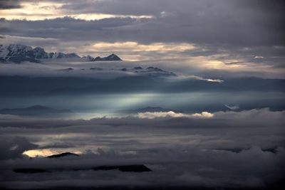 Scenic view of snowcapped mountains amidst cloudscape during sunset