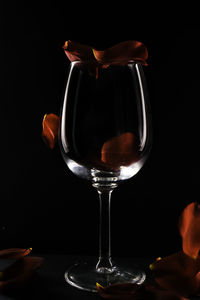 Close-up of wine glass on table against black background