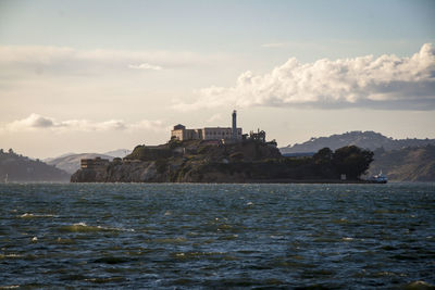 Scenic view of sea by buildings against sky