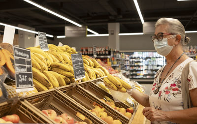 Senior woman holding banana at store