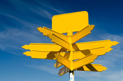 Low angle view of road sign against blue sky