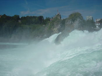 Scenic view of waterfall against sky