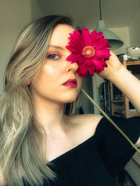 Portrait of woman with pink flower