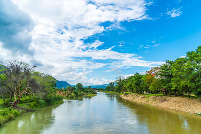 River amidst trees against sky