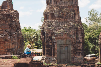 Woman sitting outside temple