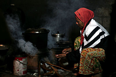 Side view of senior woman cooking food