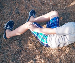 High angle view of boy lying on field