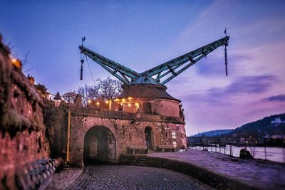 Cranes by river against sky