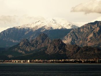 River by snow covered mountains against sky