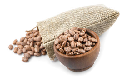 High angle view of roasted coffee beans against white background