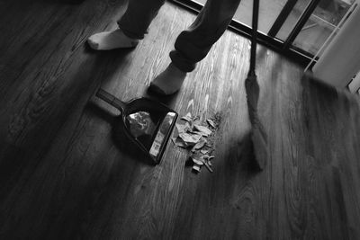 Low section of person wearing shoes on hardwood floor