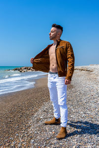 Full length of young man standing on beach