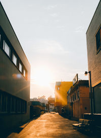 Street amidst buildings against sky during sunset