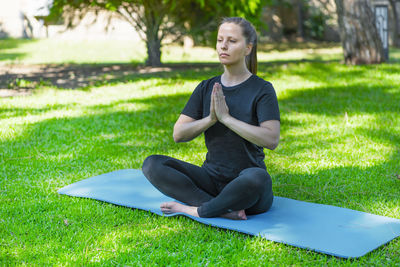 Portrait of young woman exercising on field