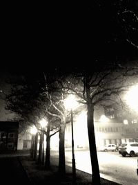 Illuminated street light against sky at night