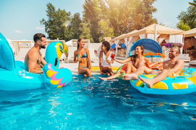 Happy friends enjoying together in swimming pool