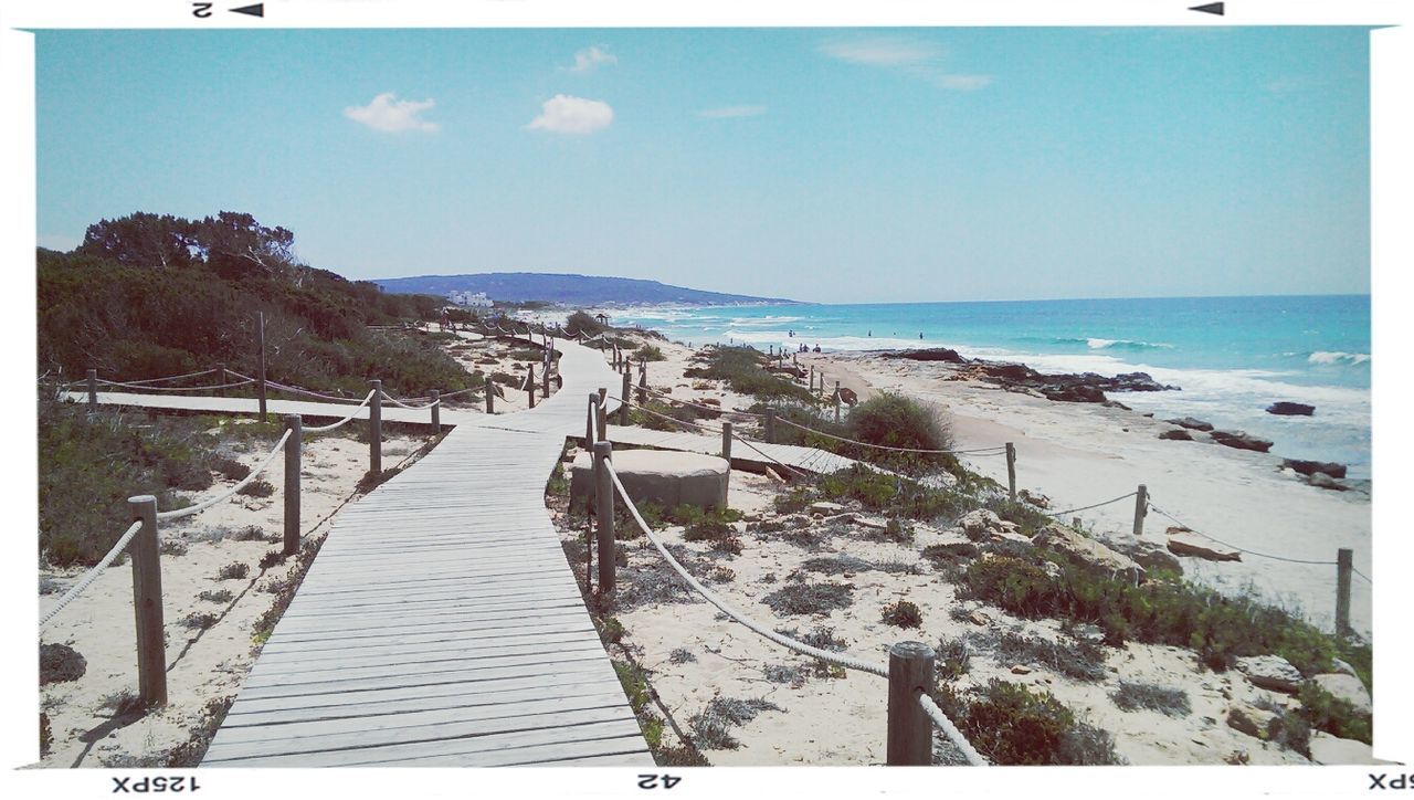 sea, beach, water, horizon over water, sky, transfer print, the way forward, tranquil scene, sand, shore, scenics, tranquility, blue, beauty in nature, nature, incidental people, sunlight, auto post production filter, railing, day