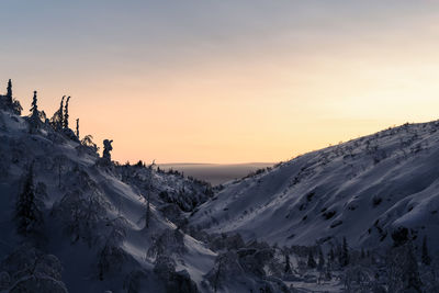 Scenic view of snow covered mountains against sky during sunset