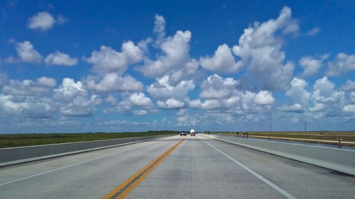 Road by landscape against sky