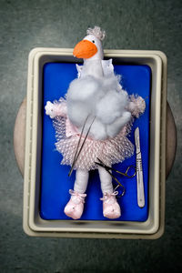 Directly above shot of toy with surgical equipment in medical tray on table