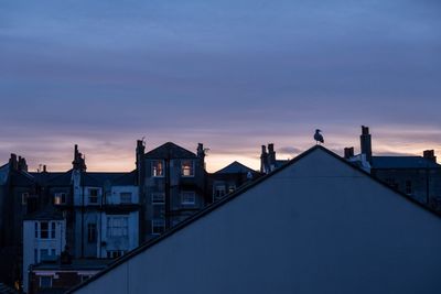 Buildings against cloudy sky at dusk