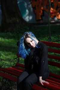 Woman sitting on bench in park