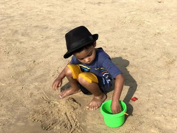 High angle view of boy playing on sand