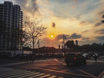 City street against sky at sunset