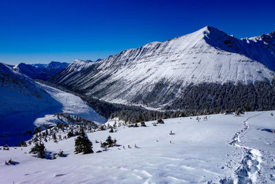 Scenic view of snowcapped mountains against clear blue sky