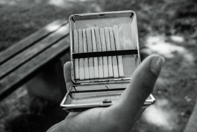 Cropped hand of person holding cigarette pack