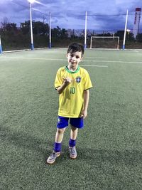 Full length of boy playing soccer on field