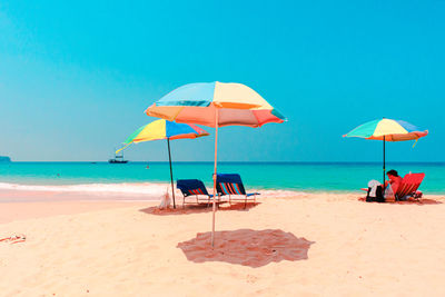 Parasols on beach against clear sky
