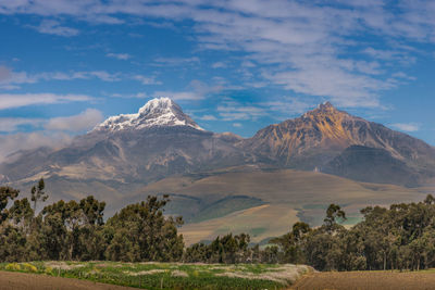 Scenic view of mountains against blue sky