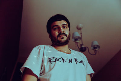 Portrait of young man standing against wall