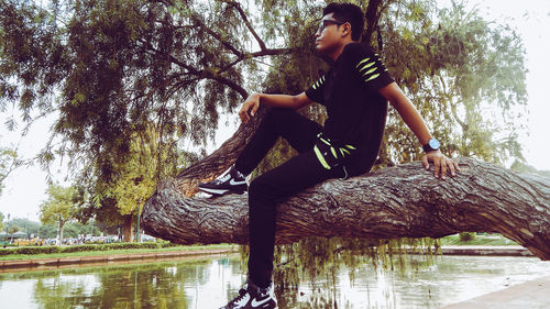 Man sitting by tree in lake