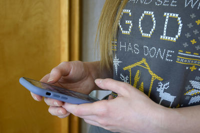 Girl holds samrtphone in her hands. she browses information on mobile phone screen. close-up.