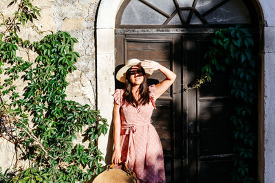 Full length of woman standing against wall