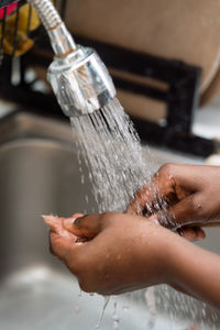 Woman washing a cup in the sink