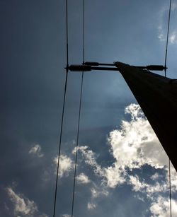 Low angle view of power lines against cloudy sky