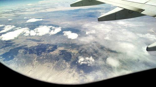 Cropped image of airplane wing over landscape