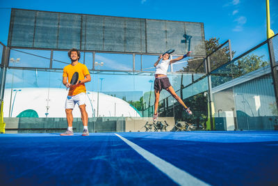 Men playing tennis in court