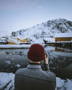 Rear view of woman looking at snowcapped mountains during winter