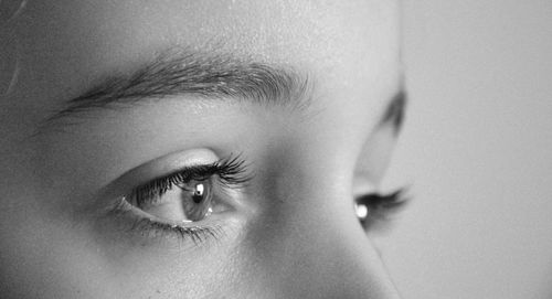 Close-up of woman looking away against wall