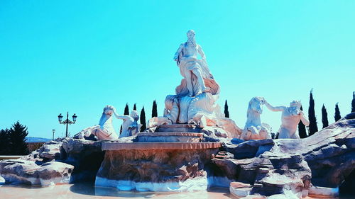 Low angle view of statue against clear blue sky