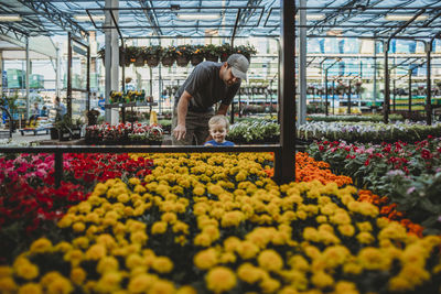 Father with son looking at flowers in greenhouse