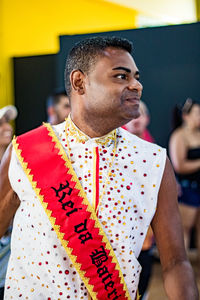 Man wearing red sash while standing indoors