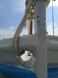 Close-up of rope tied to bollard against sky