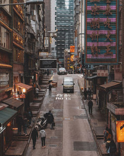 High angle view of people walking on street amidst buildings in city