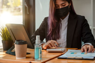 Midsection of woman using mobile phone on table